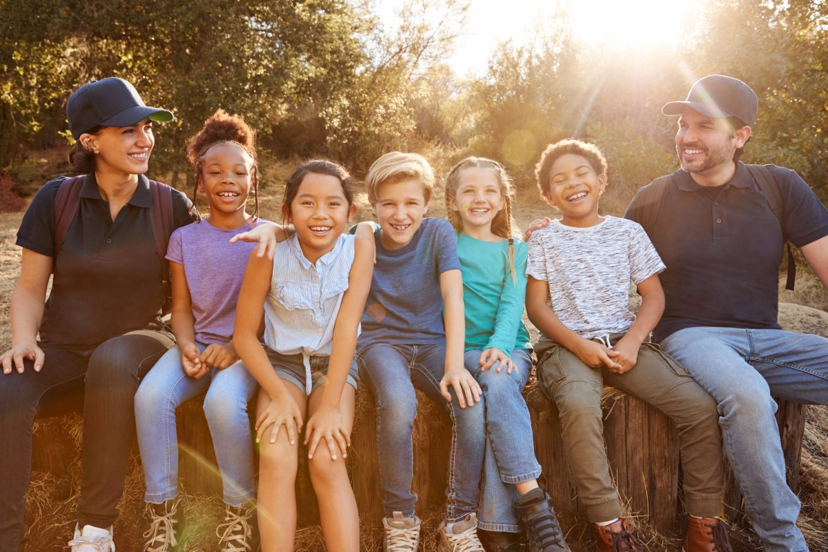 Portrait Of Adult Team Leaders With Group Of Children At Outdoor Activity Camp